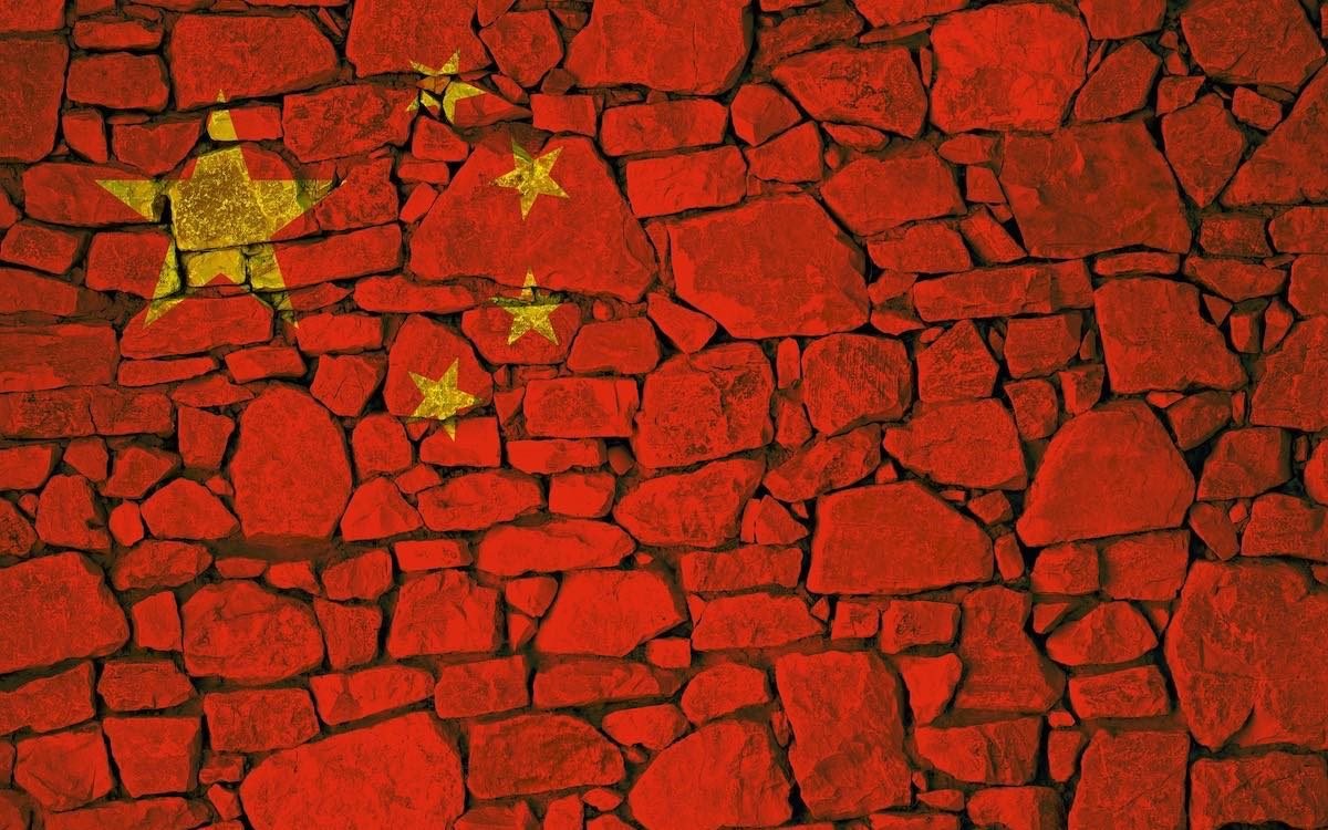 The image shows a Chinese flag imposed on a brick wall to illustrate China’s Great Firewall. Clubhouse managed to breach the censors before the audio app was closed down.