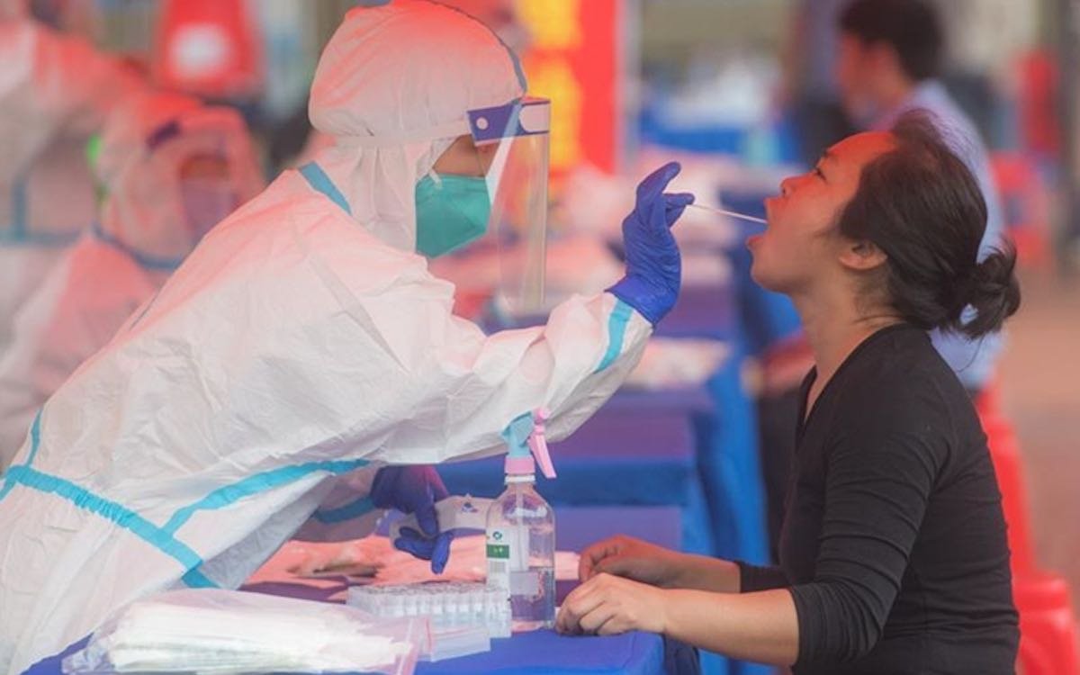 The image shows a Wuhan resident being tested for Covid-19 in 2020. Beijing is still pushing the theory that the virus could have been transmitted through imported frozen food.