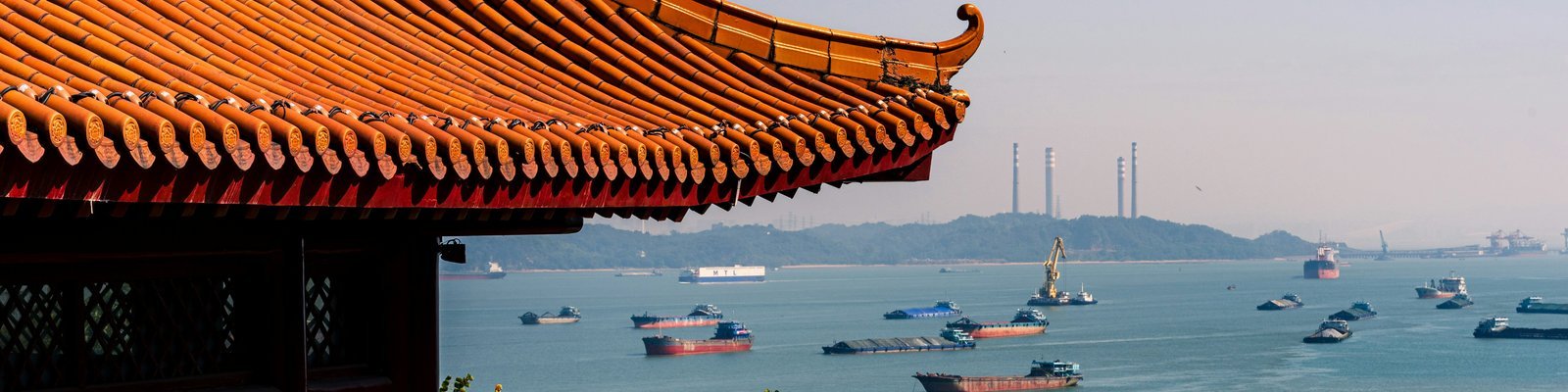 Temple overlooking shipping vessels on Chinese waterway