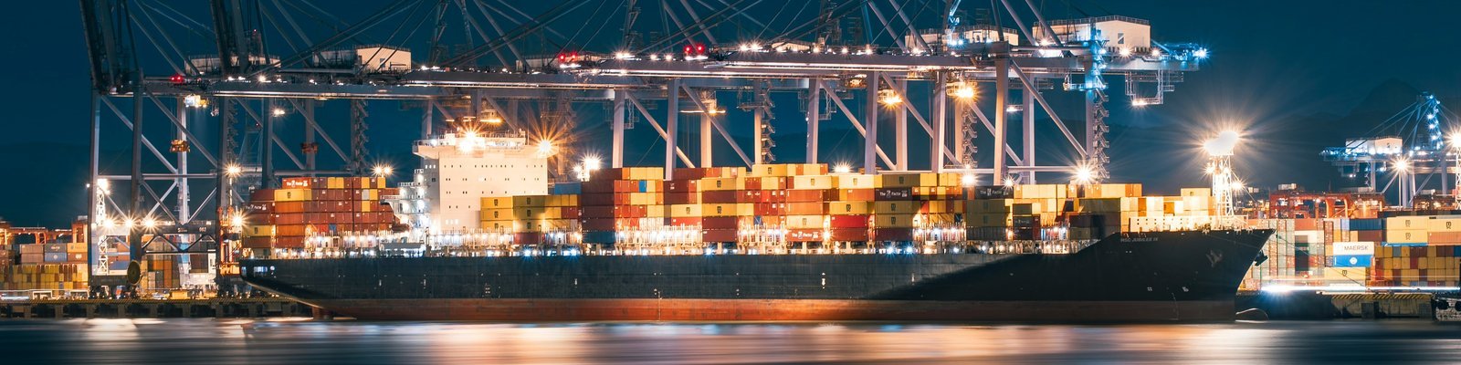 Container port with shipping cranes at night